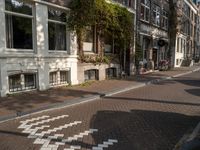 an empty sidewalk is shown in a city area, with brick pavements and parked motorcycles