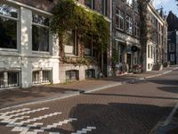 an empty sidewalk is shown in a city area, with brick pavements and parked motorcycles