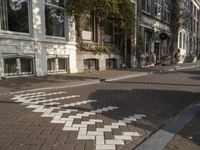 an empty sidewalk is shown in a city area, with brick pavements and parked motorcycles