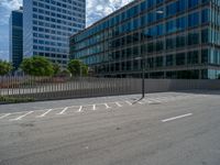 an empty parking lot in a city with high rise buildings in the background with a white line painted across