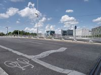 a bicycle lane that looks empty under the blue sky with clouds and bright blue skies