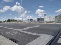 a bicycle lane that looks empty under the blue sky with clouds and bright blue skies