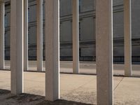 the corner of a building with columns near by it, on which there is an image of a person riding a bike