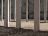 the corner of a building with columns near by it, on which there is an image of a person riding a bike