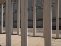 the corner of a building with columns near by it, on which there is an image of a person riding a bike