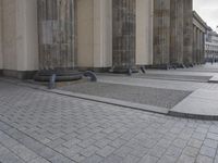there are steps to put in between a building and another area with large pillars and some benches