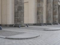 there are steps to put in between a building and another area with large pillars and some benches