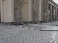 there are steps to put in between a building and another area with large pillars and some benches