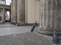 there are steps to put in between a building and another area with large pillars and some benches
