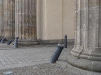 there are steps to put in between a building and another area with large pillars and some benches