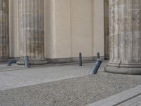 there are steps to put in between a building and another area with large pillars and some benches