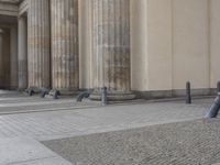 there are steps to put in between a building and another area with large pillars and some benches