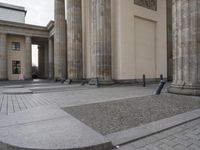 there are steps to put in between a building and another area with large pillars and some benches