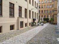 a very small narrow cobble stone street with an old motorcycle parked in the middle