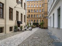 a very small narrow cobble stone street with an old motorcycle parked in the middle