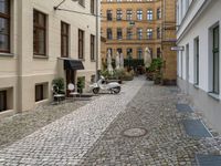 a very small narrow cobble stone street with an old motorcycle parked in the middle