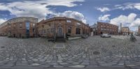 this is a spherical 360 - vr image taken on a cobblestone surface looking like it is in an urban area