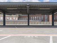 empty parking lot at station with no parking written on it and cloudy sky above it