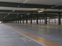 a man standing in the middle of an empty parking garage area with a sign on the floor