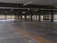 a man standing in the middle of an empty parking garage area with a sign on the floor