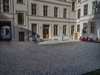 an empty parking lot with plants in the ground and on the side of the building, there is an enclosed area and windows