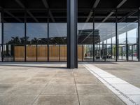 the entrance to a building with a wall of windows and large wooden panels above it