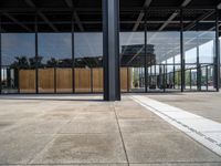 the entrance to a building with a wall of windows and large wooden panels above it