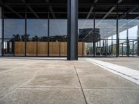 the entrance to a building with a wall of windows and large wooden panels above it