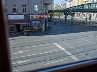 a street view is seen through a window at an intersection with buildings and cars passing by