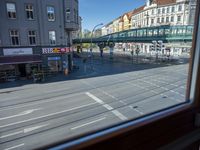 a street view is seen through a window at an intersection with buildings and cars passing by