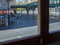 a street view is seen through a window at an intersection with buildings and cars passing by