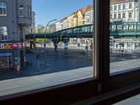 a street view is seen through a window at an intersection with buildings and cars passing by