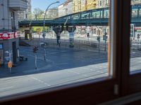 a street view is seen through a window at an intersection with buildings and cars passing by