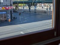 a street view is seen through a window at an intersection with buildings and cars passing by