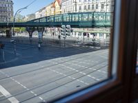 a street view is seen through a window at an intersection with buildings and cars passing by