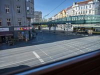 a street view is seen through a window at an intersection with buildings and cars passing by