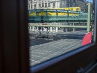 a street view is seen through a window at an intersection with buildings and cars passing by