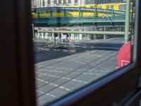 a street view is seen through a window at an intersection with buildings and cars passing by