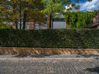 a long empty brick street with tall buildings in the background on a sunny day with some people walking around