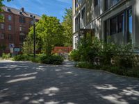 a paved brick street with red trash bins sitting in the middle and trees near to it