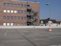 this is an empty parking lot with buildings in the background and a fire escape ladder