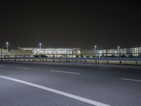 an empty parking lot by some high rise buildings at night, with no cars in the photo
