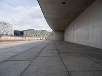 a concrete hallway with many buildings in the background, and no one standing behind it