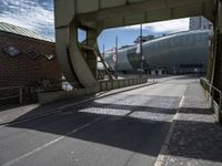 the empty street is lined with brick streets and buildings near by, as the sun shines in