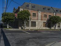 an empty road next to a large brick building with several windows and windows on the top story