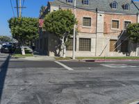 an empty road next to a large brick building with several windows and windows on the top story