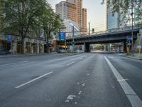 a city street that has a bridge over the road at sunset on a clear day