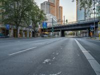 a city street that has a bridge over the road at sunset on a clear day