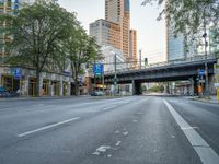 a city street that has a bridge over the road at sunset on a clear day