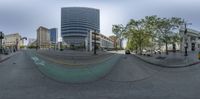 an spherical photo shows some tall buildings in the distance and a bike path leading to the right side